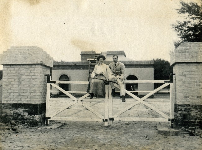 Verna and Vic Manning sitting on fence.